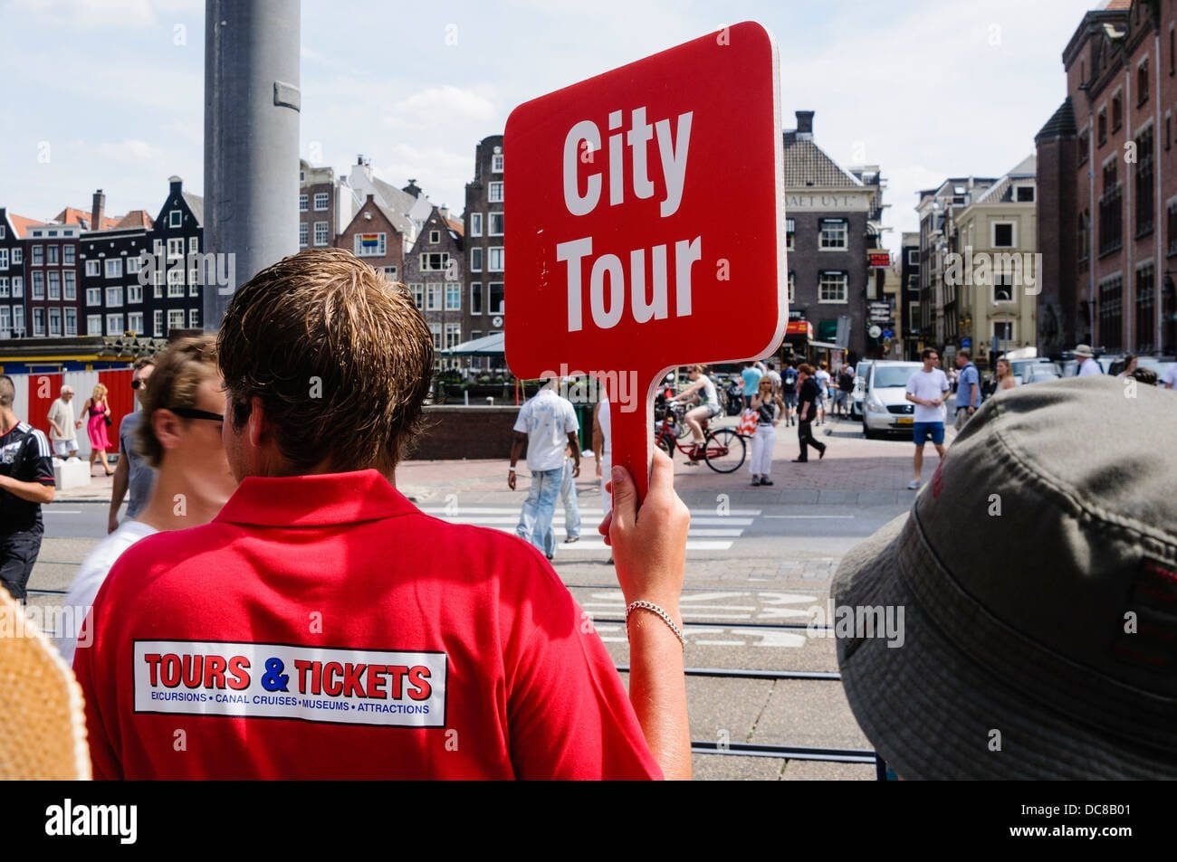 a-tour-guide-holds-a-sign-for-the-city-tour-in-amsterdam-DC8B01